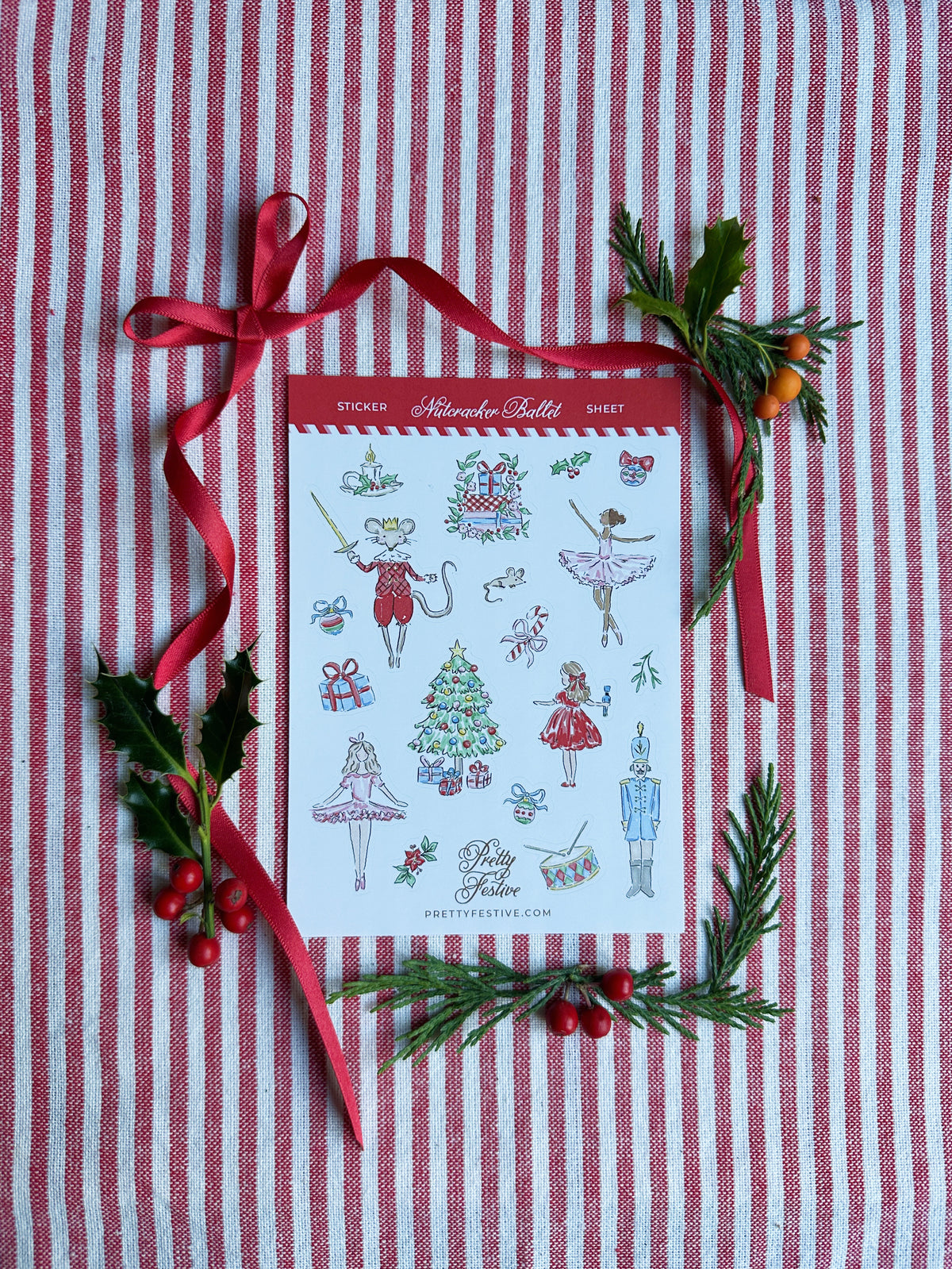 A6 Sticker Sheet caption Nutcracker Ballet featuring several Christmas Nutcracker Ballet themed illustrations. Background is red and white striped fabric, red ribbon and foliage and berries