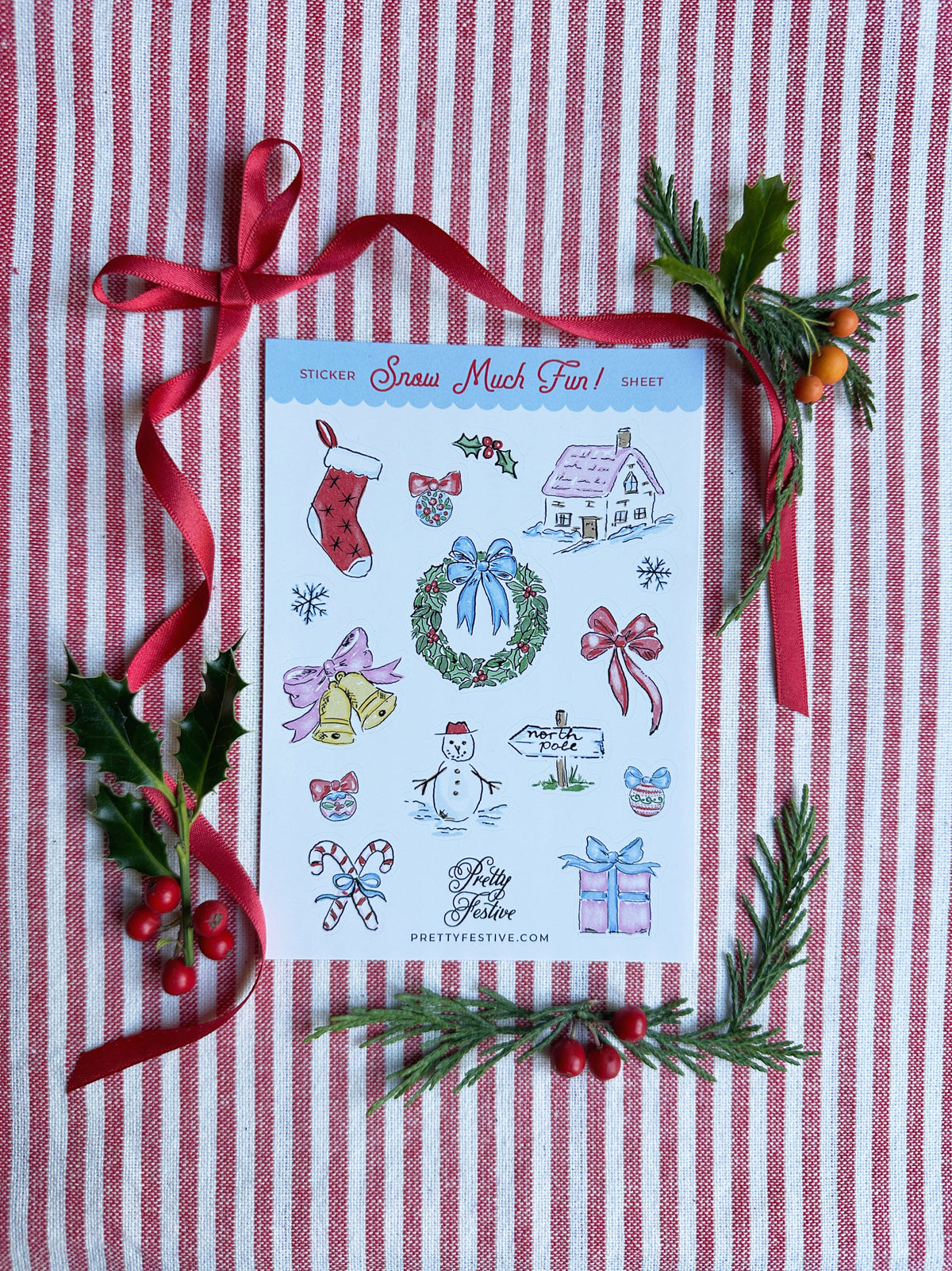 A6 Sticker Sheet caption Snow Much Fun featuring several Christmas themed illustrations. Background is red and white striped fabric, red ribbon and foliage and berries
